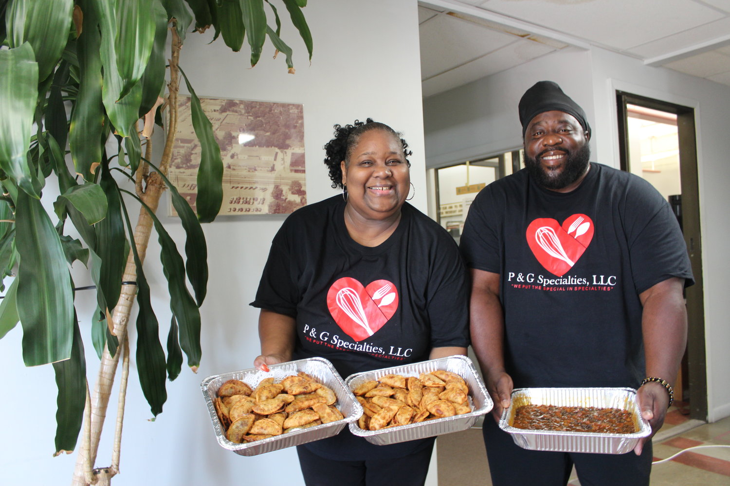 Regina Hunt and Paul Coffey, who are launching P & G Specialties LLC,  show off their culinary skills: Hunt’s savory empanadas and Coffey’s bean dish. Different variations are offered, and yellow rice and dipping sauce are also their creations.